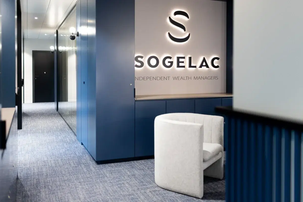 Espace d'accueil moderne de l'entreprise Sogelac avec logo lumineux et fauteuil blanc.