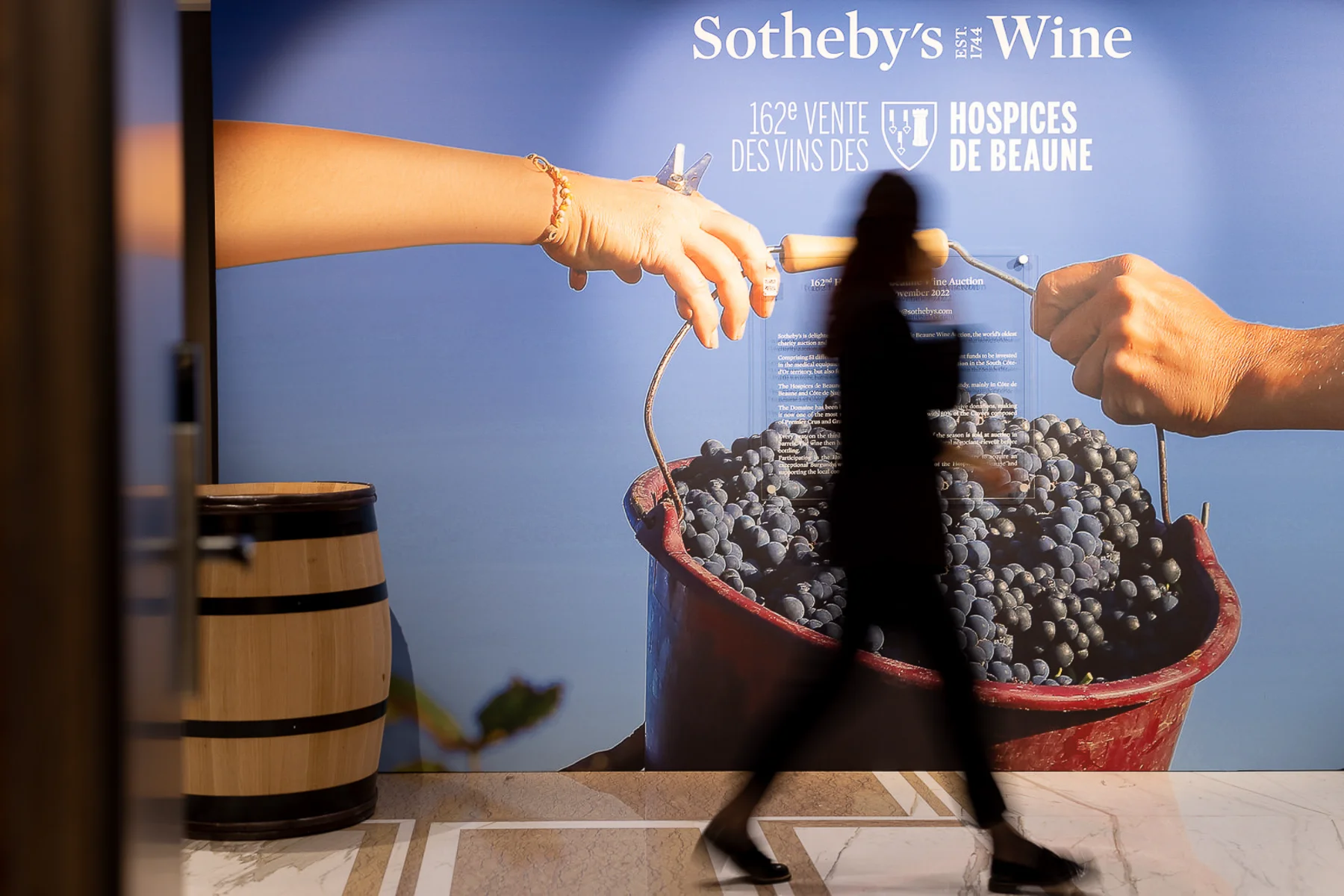 Reportage d'un photographe corporate Lyon montrant une silhouette floue devant l'affiche des Hospices de Beaune.