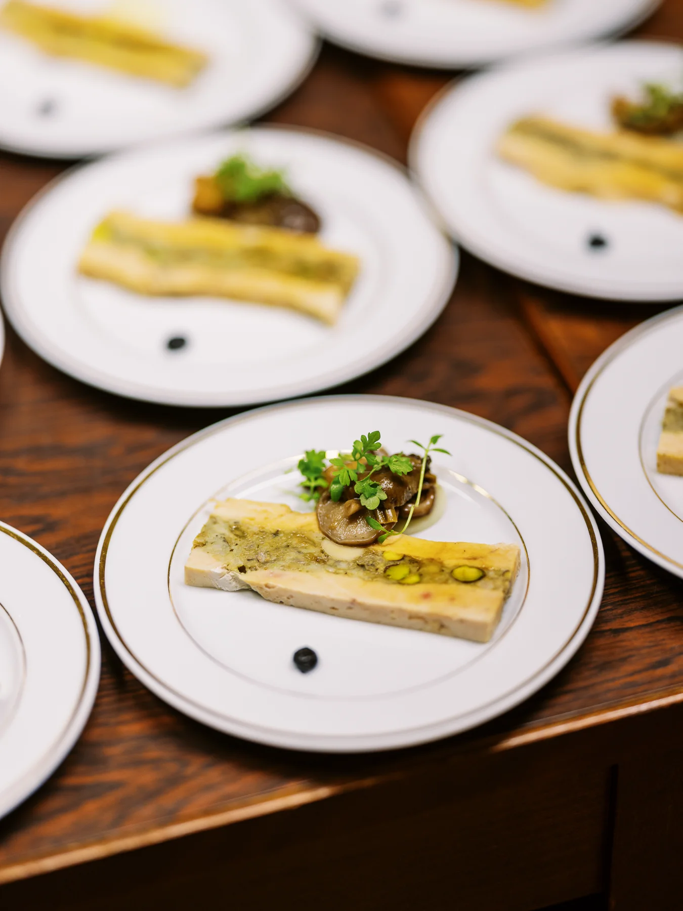 Photos événement Lyon montrant des tranches de terrine de foie gras sur assiettes en porcelaine.