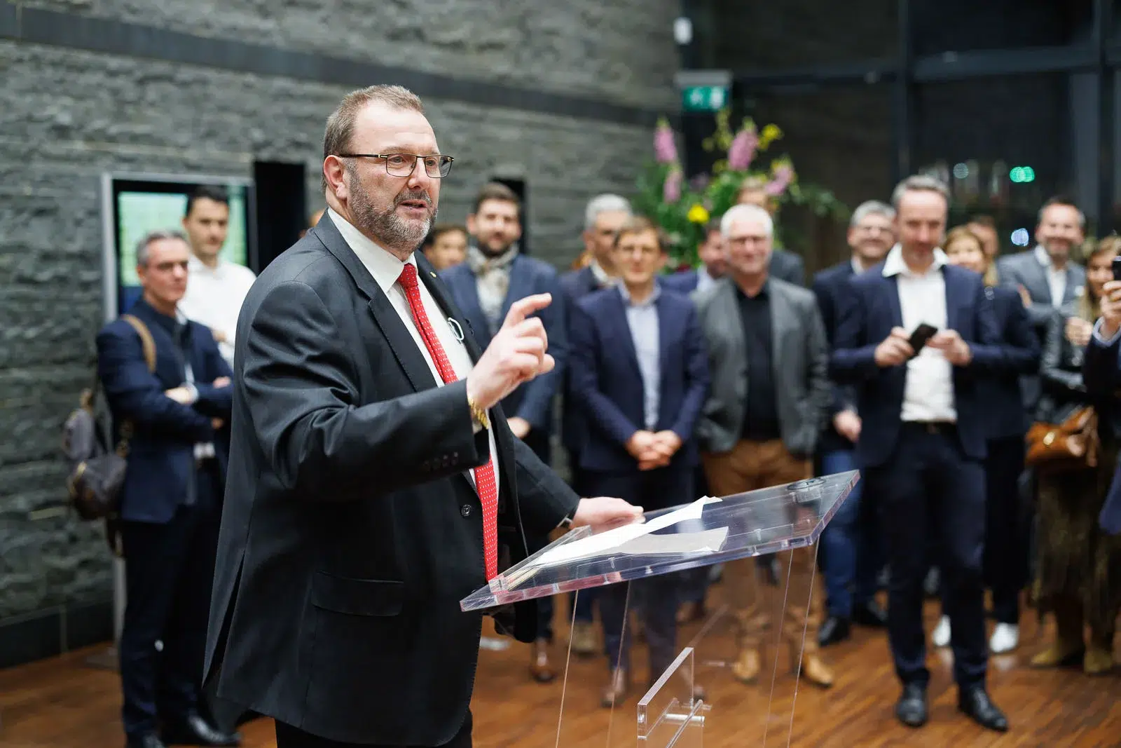 Photographe événementiel Lyon : un homme en costume prononce un discours devant un public attentif lors d'une réception.