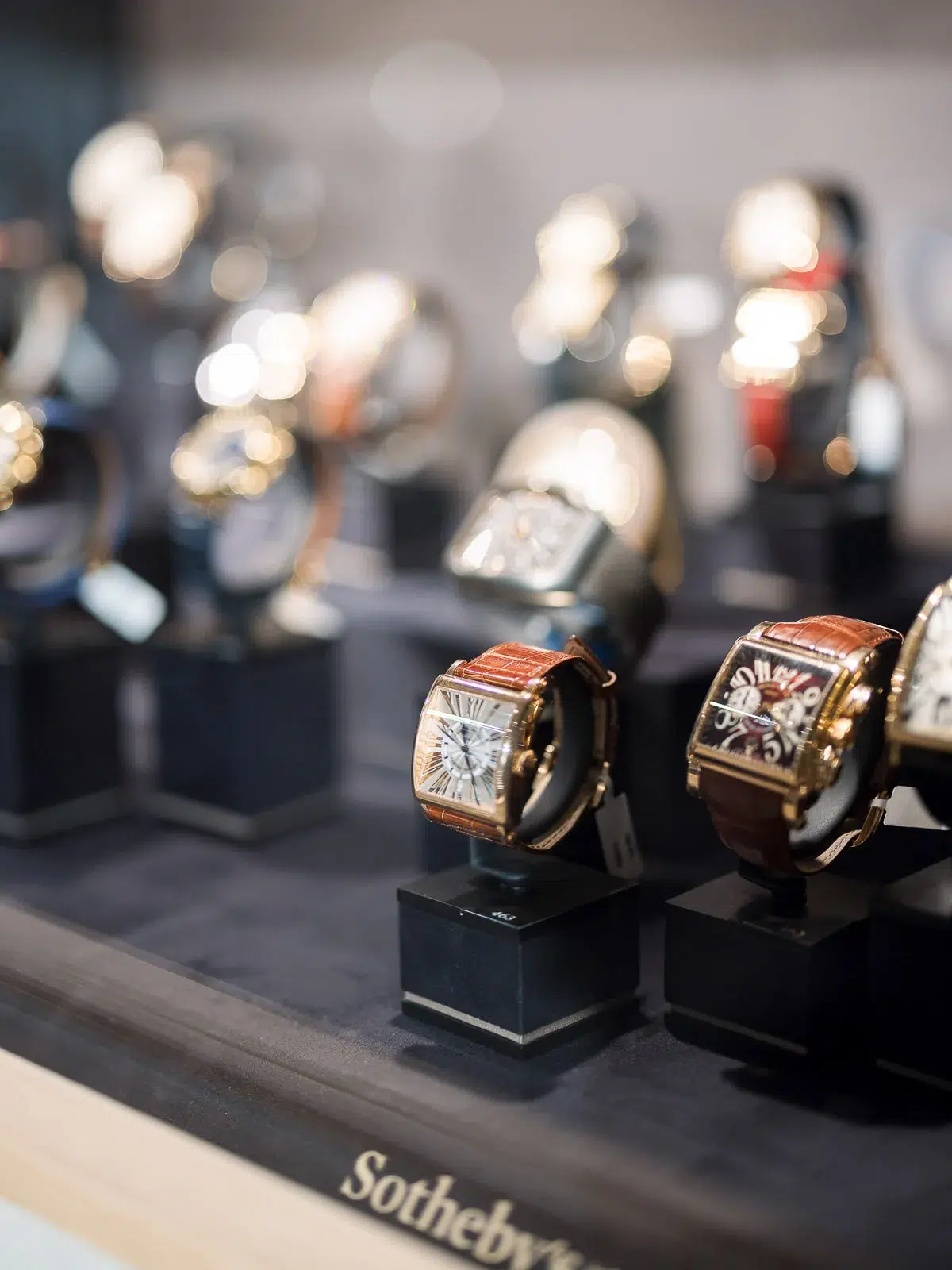 Photographe event Lyon : gros plan sur des montres de luxe exposées sur des présentoirs lors d'un événement Sotheby's.