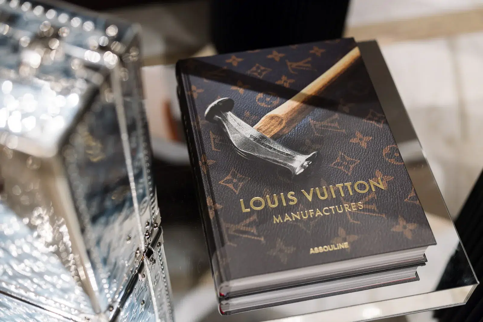 Photographe événementiel Lyon : gros plan sur un livre 'Louis Vuitton Manufactures' posé sur une table en verre.