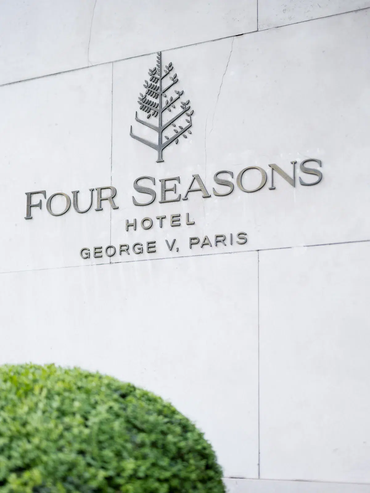Photographe événementiel Lyon : détail de la façade en pierre du Four Seasons Hotel George V à Paris avec son logo.
