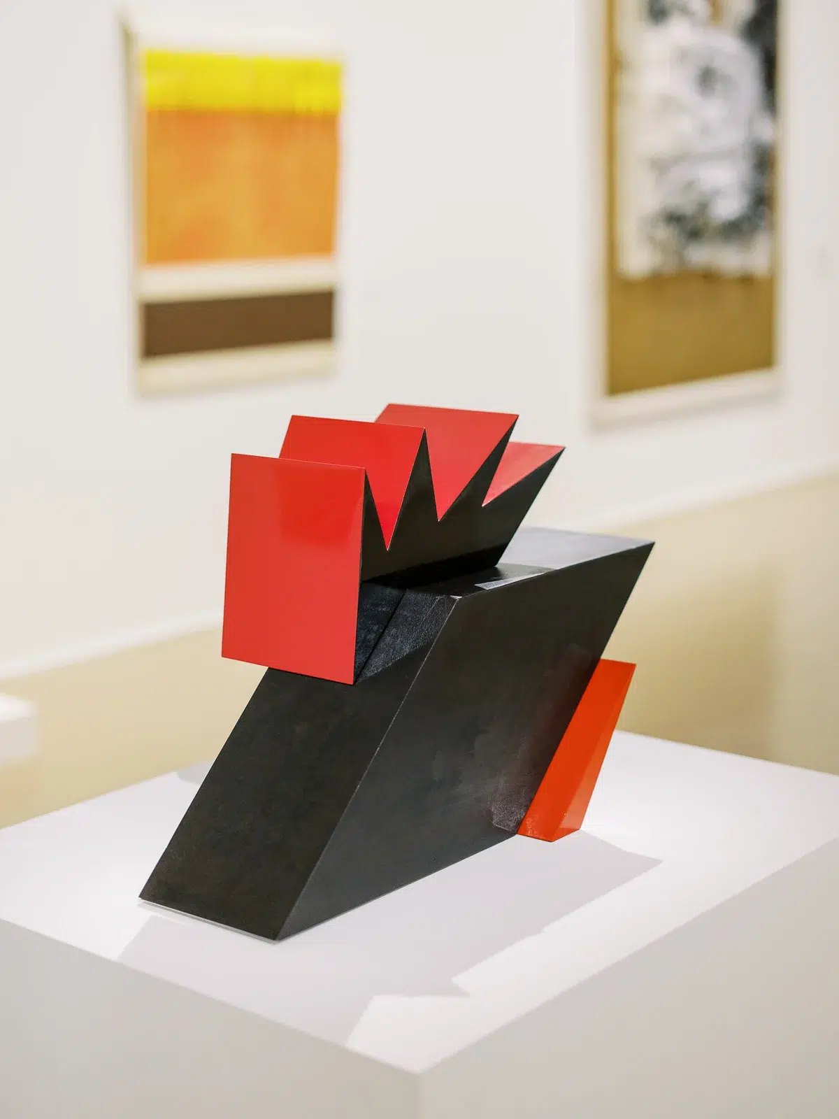 Photographe événementiel Lyon : vue détaillée d'une sculpture géométrique rouge et noire lors d'une exposition d'art.