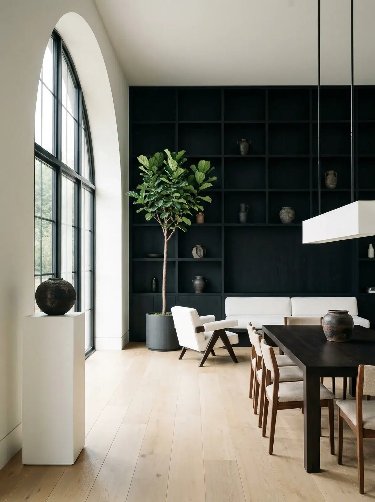 Intérieur minimaliste capturé par un photographe architecture lyon avec grande fenêtre en arche et étagère noire.