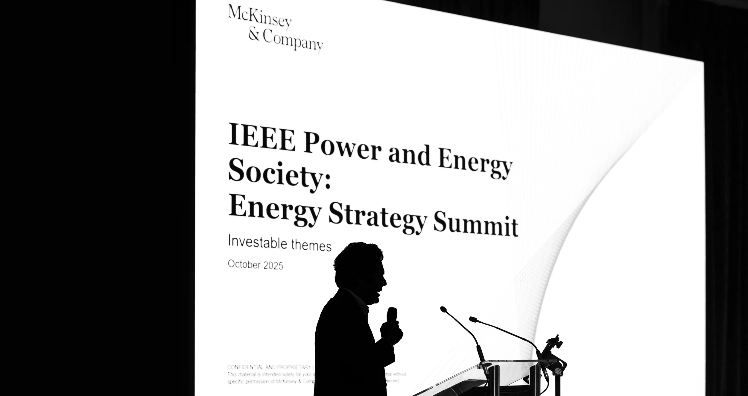 Photographe Lyon : silhouette d'un orateur au pupitre lors du sommet IEEE Energy Strategy devant un écran lumineux.