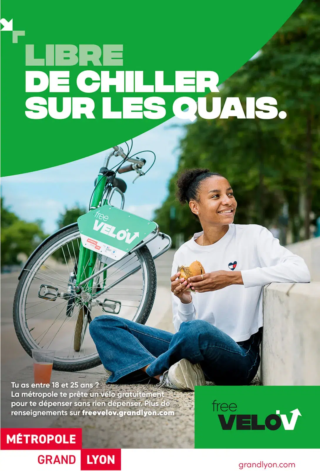 Jeune femme déjeunant sur les quais avec un Free Velo'v, photo pub Lyon.