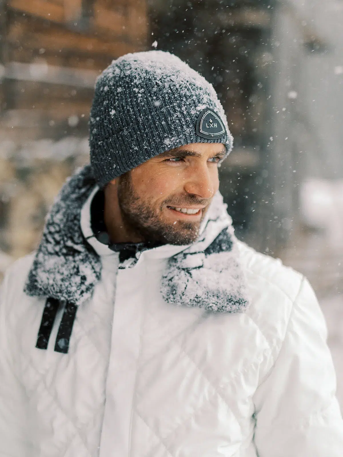 Photographe portrait Lyon : homme barbu sous la neige portant un bonnet gris LXH.