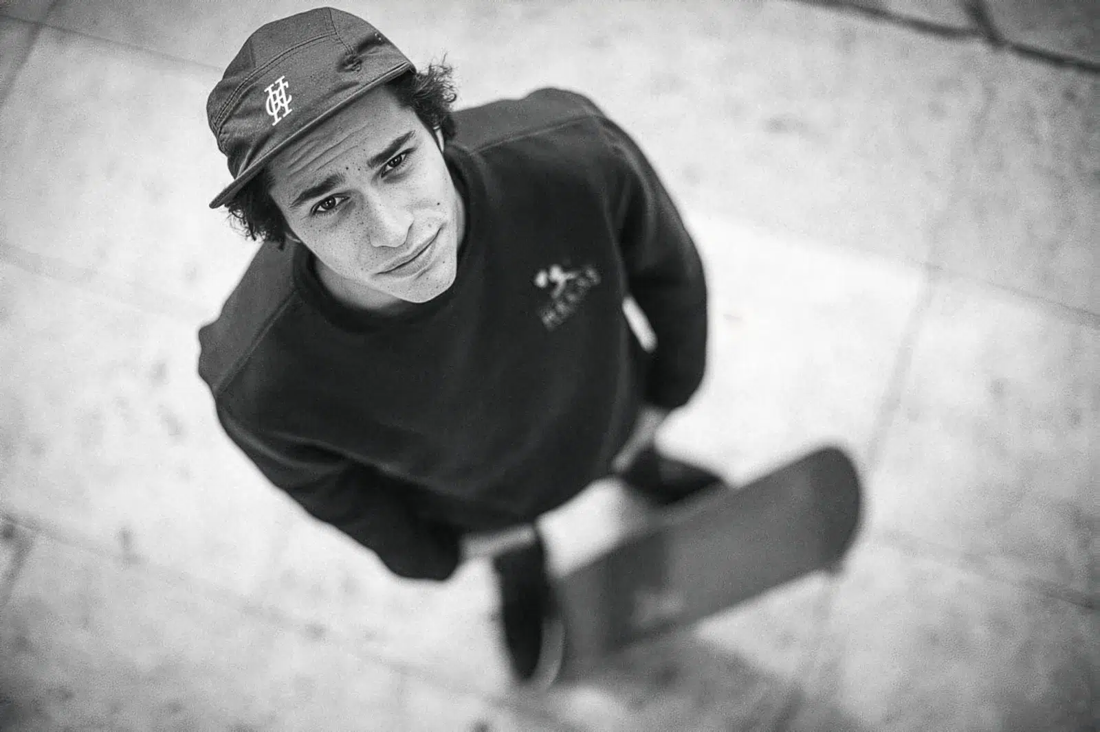 Photographe portrait Lyon : jeune skateur vu de dessus en noir et blanc avec sa planche.