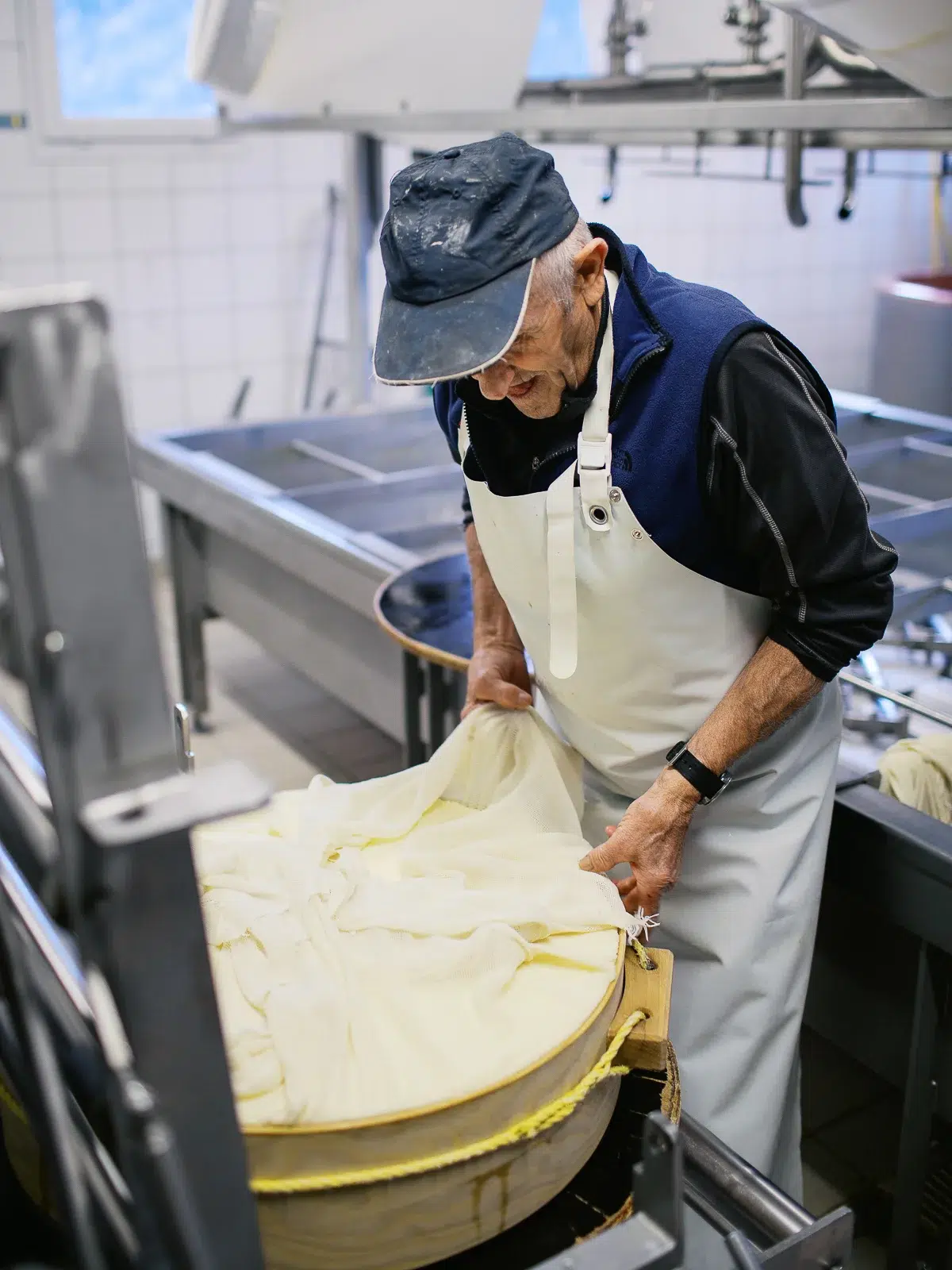 Photo reportage Rhône Alpes : Un artisan fromager place le caillé dans un moule recouvert d'une toile.