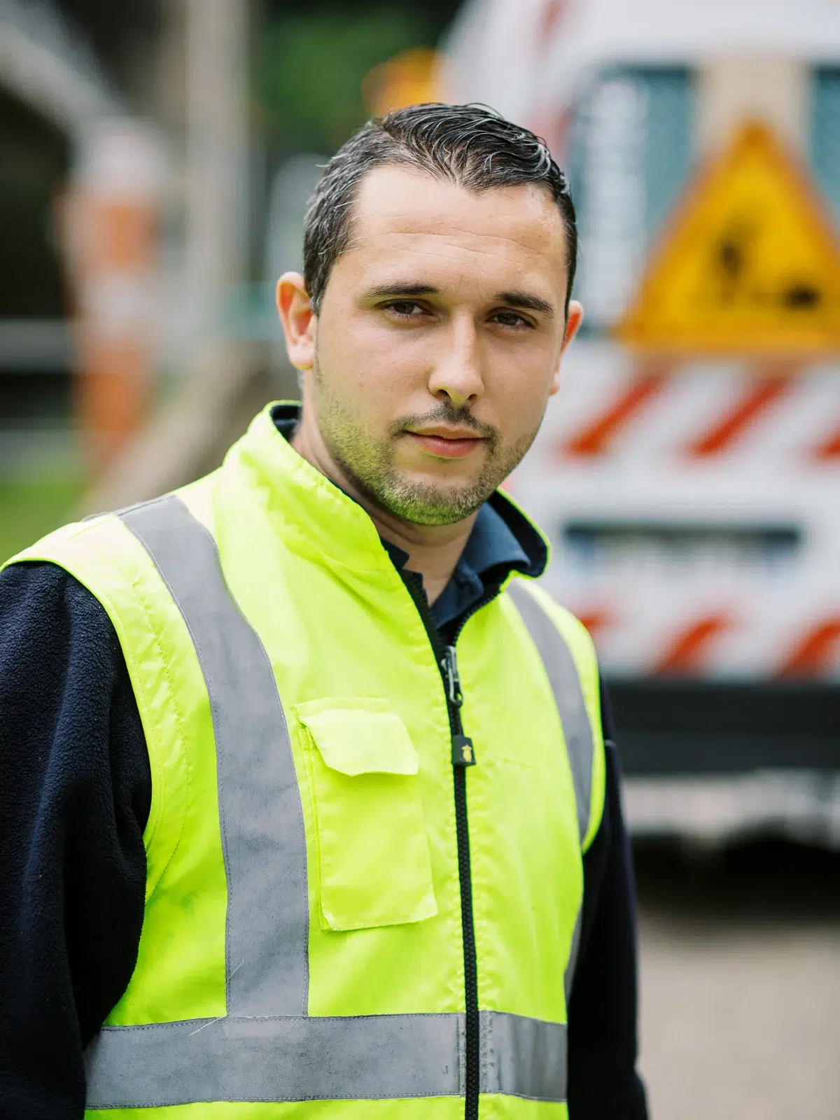 Photo reportage Rhône Alpes : Portrait d'un agent de sécurité portant un gilet jaune haute visibilité.