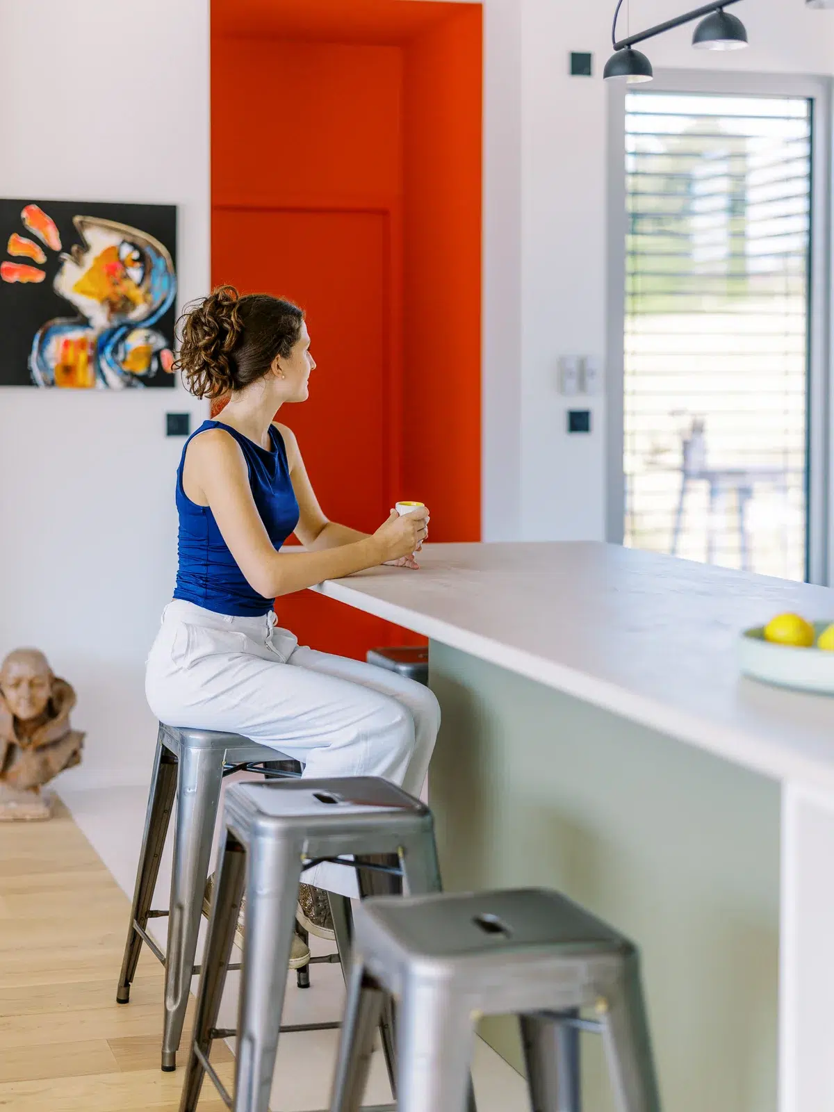 Photographe architecture Lyon illustrant une cuisine contemporaine avec un mur rouge vif.