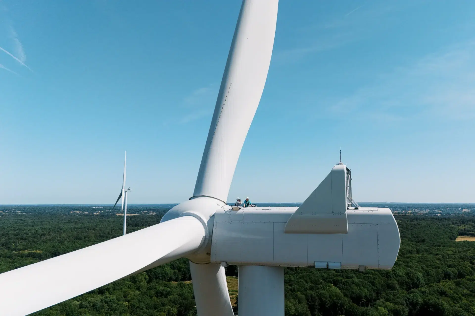Techniciens travaillant sur une éolienne en hauteur, vue par un photographe entreprise Lyon.