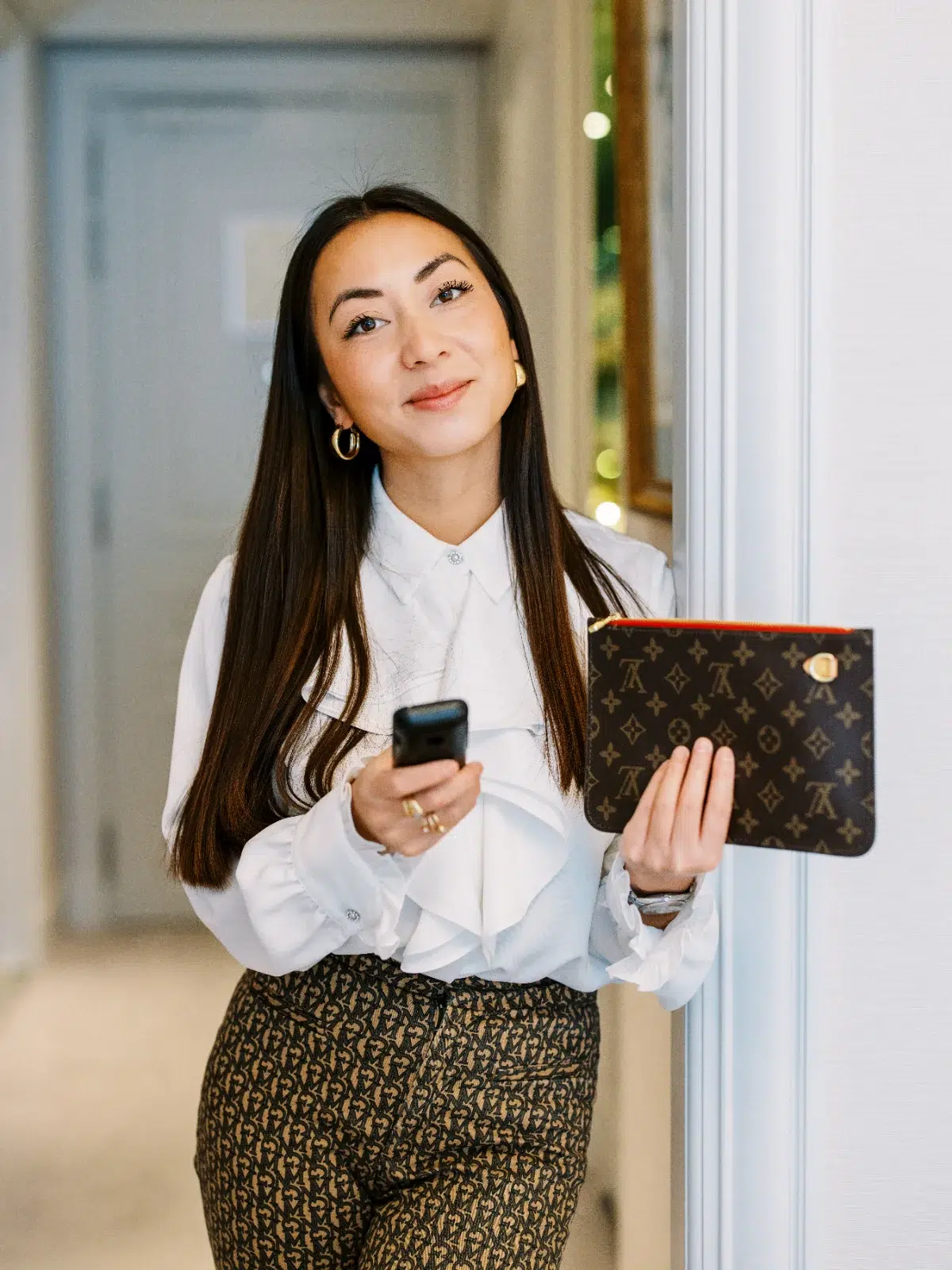Femme élégante avec pochette Louis Vuitton et smartphone, photo d'un Photographe Lyon.