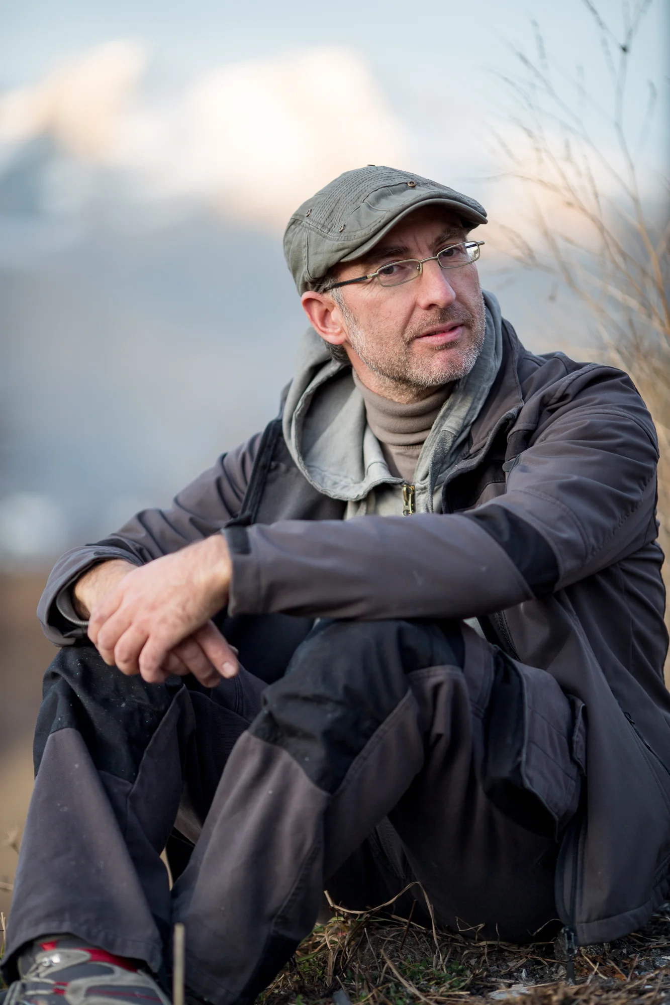 Photographe en Savoie : portrait d'un randonneur avec casquette et lunettes en montagne.