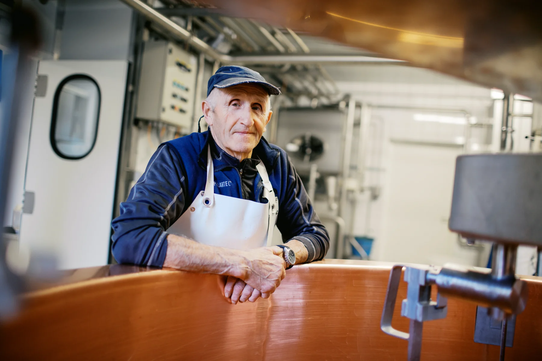 Fromager traditionnel devant sa cuve en cuivre, un exemple pour estimer le tarif d'un photographe de reportage.