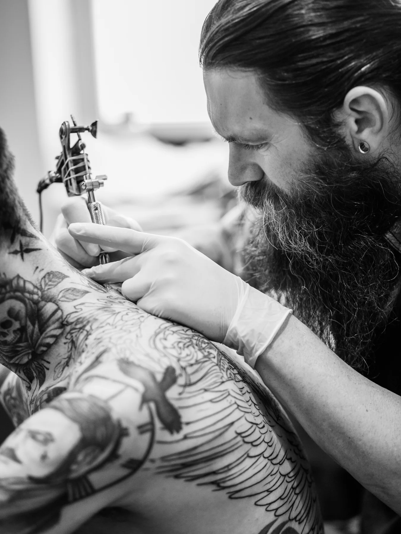 Tatoueur travaillant sur un grand motif par un photographe artistes Lyon.